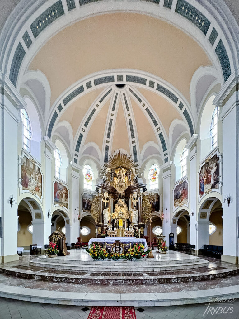 Fotografia przedstawia prezbiterium z obejściem w kościele św. Anny na osiedlu Nikiszowiec w Katowicach. Powstało w latach 1908-1924 dla górników kopalni „Giesche” z inicjatywy koncernu górniczo-hutniczego „Georg von Giesches Erben”.