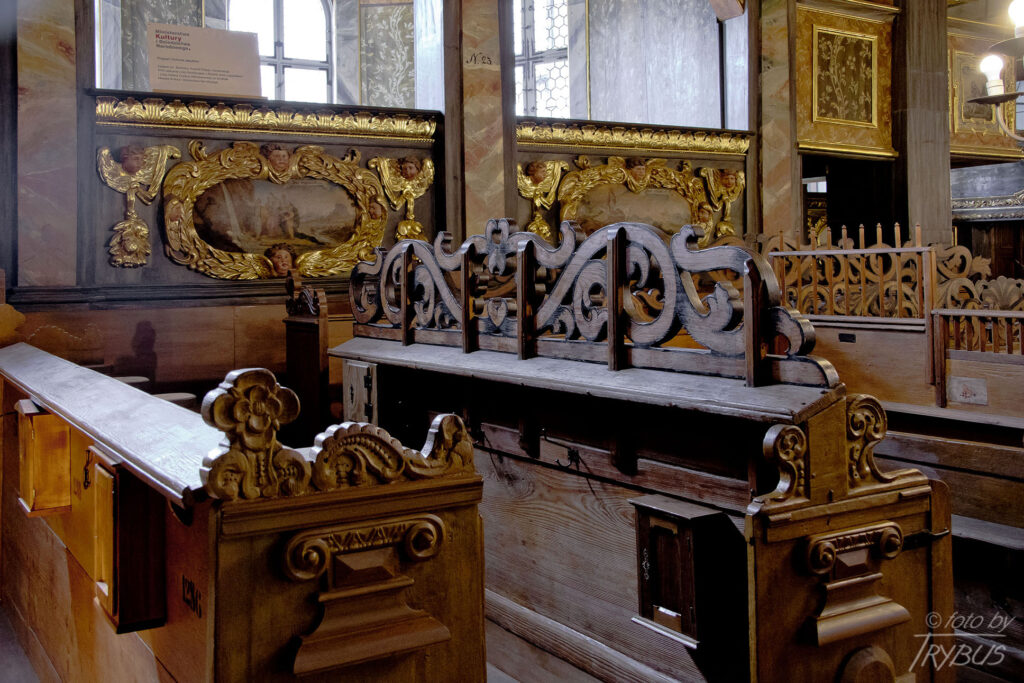 Fotografia przedstawia ławki w Kościele Pokoju w Świdnicy, za nimi widać Lożę rodziny Crusius. Jest to największa drewniana świątynia barokowa w Europie.